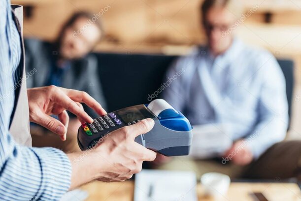 Commerciante al banco che emette uno scontrino da un registratore di cassa